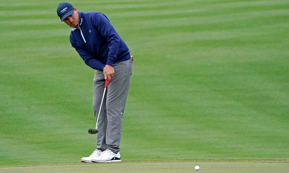 A man is playing golf on the green